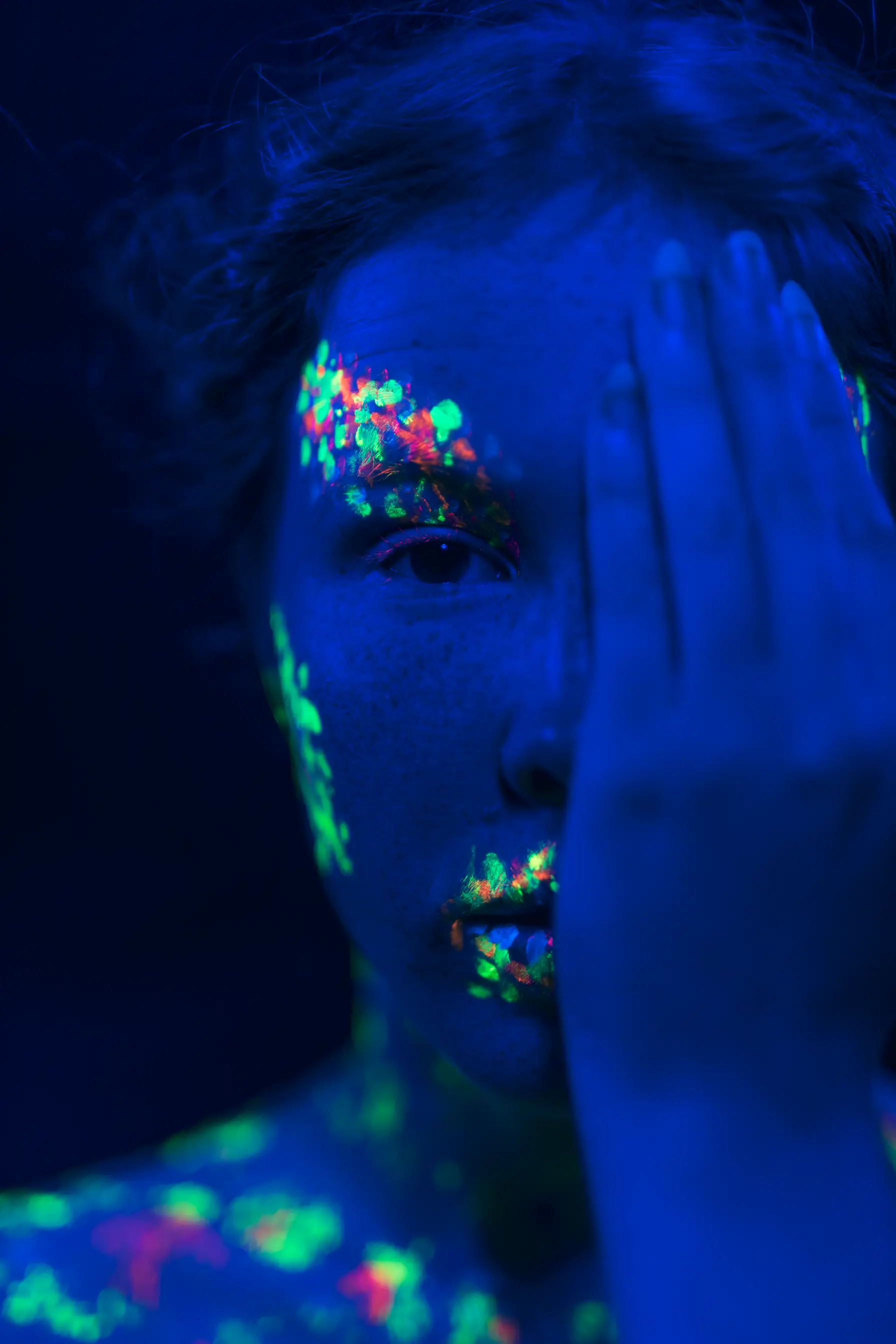 Blue Painted woman hides her left eye