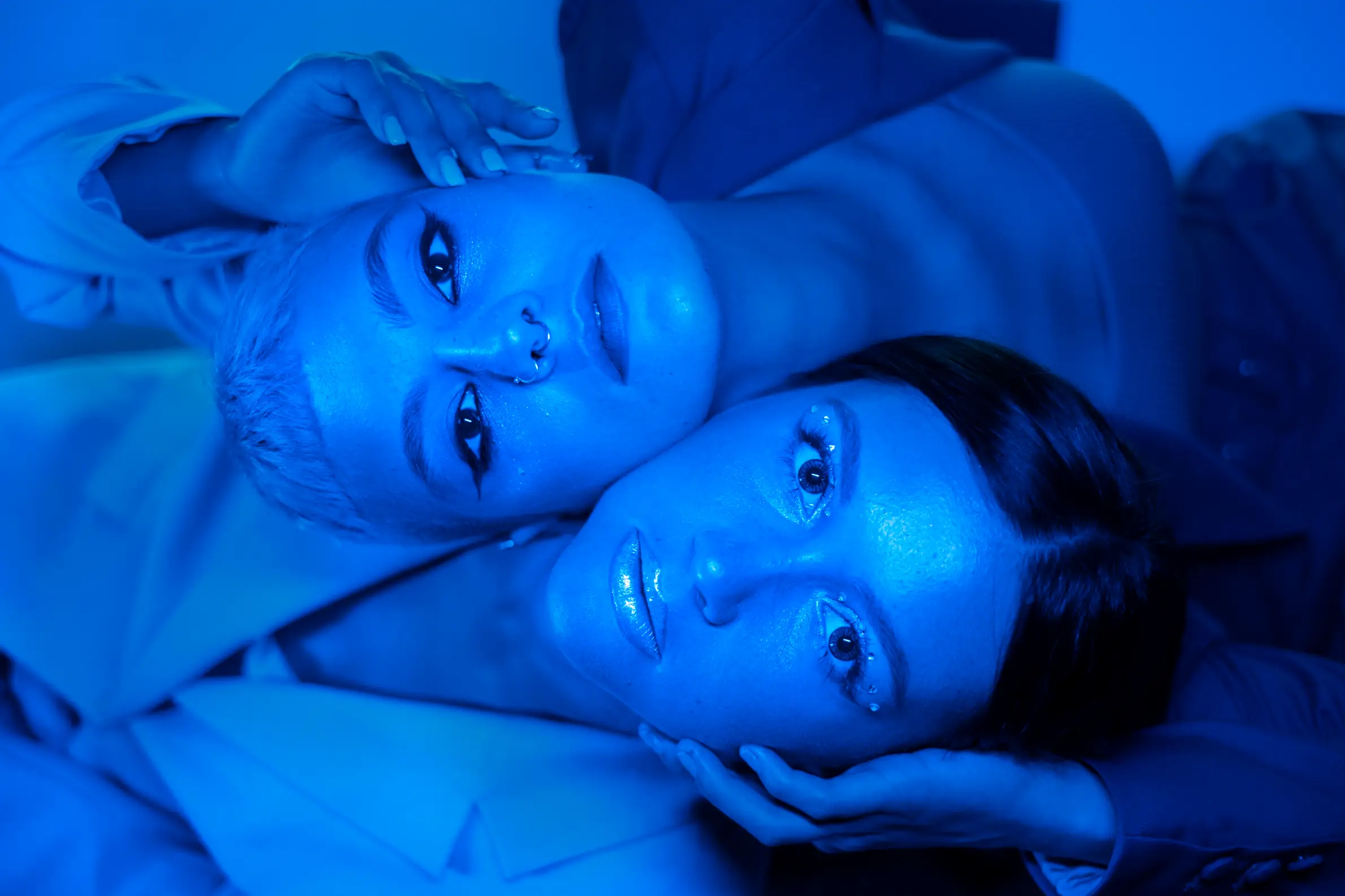 2 blue painted women laying next to each other